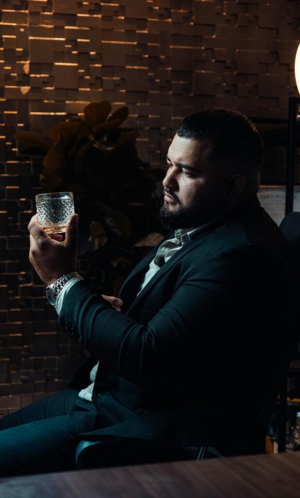 a man in a suit holding a glass of wine